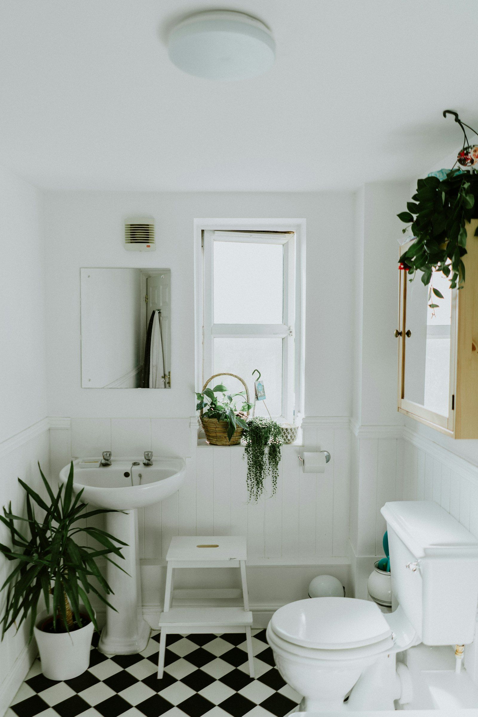Helles Badezimmer im Altbau mit Waschtisch, Wandvertäfelung und gemustertem Fliesenboden